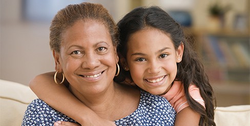 Child and adult smiling and hugging